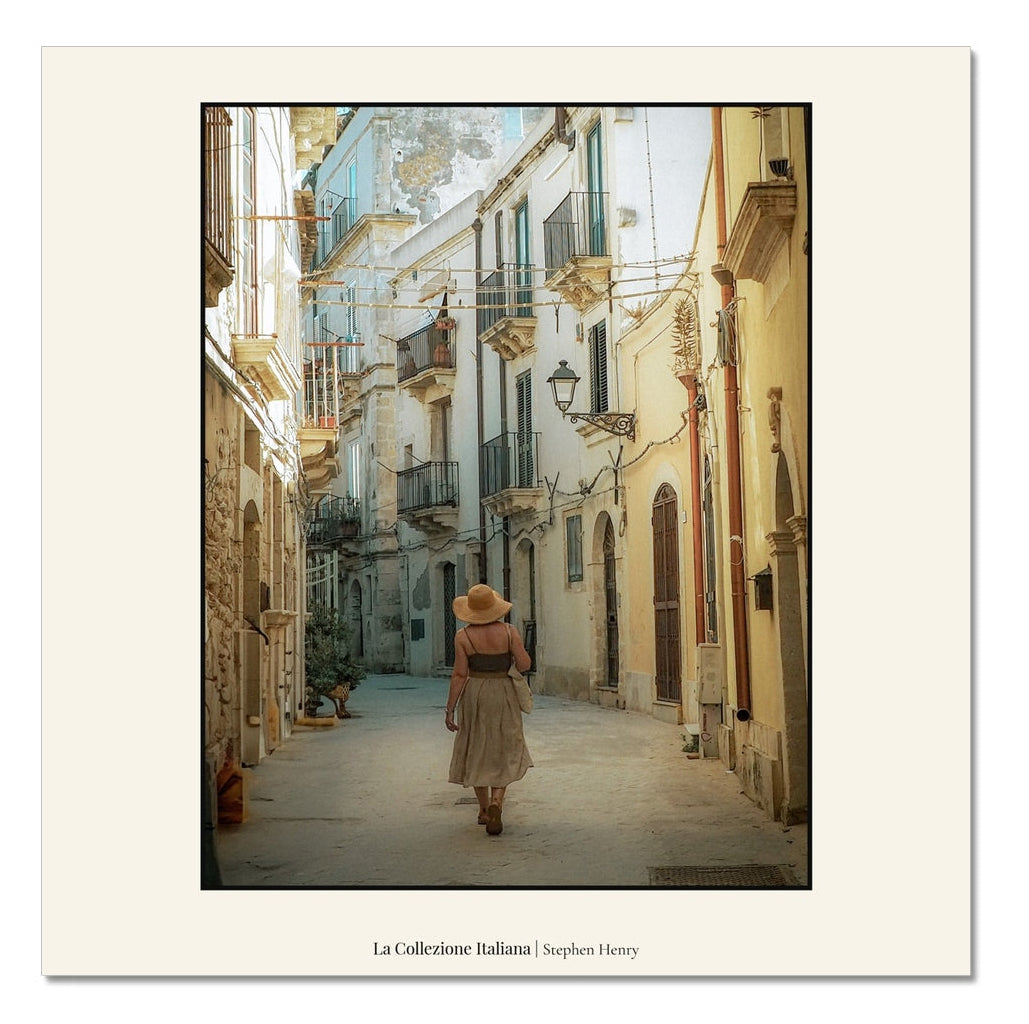 Fine art travel photograph of a beautiful woman walking in a side street in Ortigia, Sicily, Italy, part of the La Collezione Italiana wall art collection.