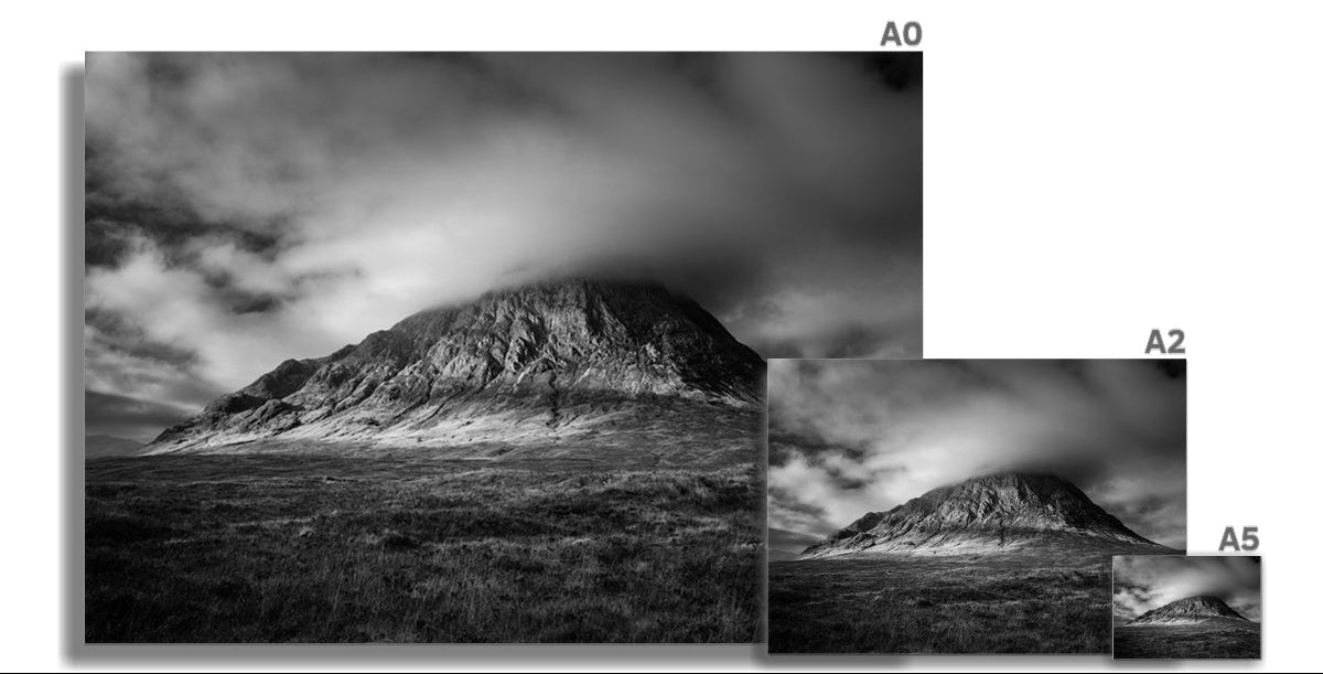 Black and white photograph of Buachaille Etive Mòr in Glencoe, with dramatic storm clouds gathering over the mountain and light breaking across its slopes.