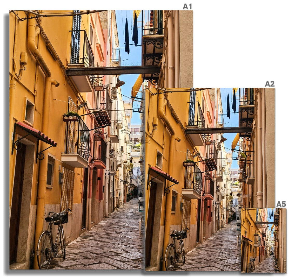 Il Vicolo fine art photograph of a narrow Italian alley with warm ochre buildings, balconies, washing and a bicycle