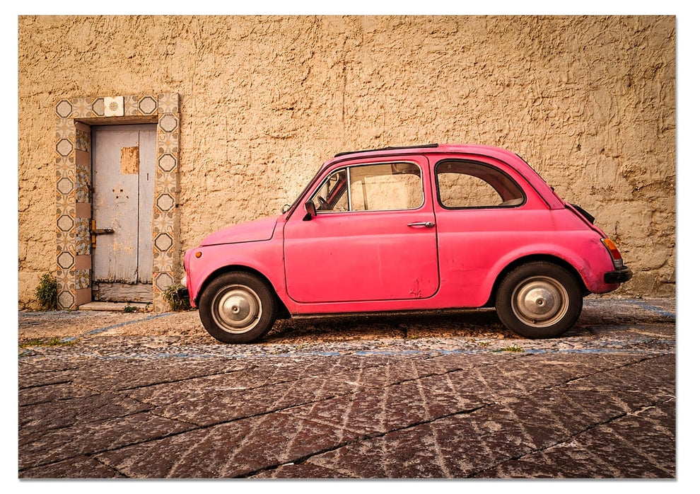 Pink vintage Fiat 500 parked beside a tiled doorway on a  Sun worn Italian street – La Cinquecento Rosa by Scotland in Frame