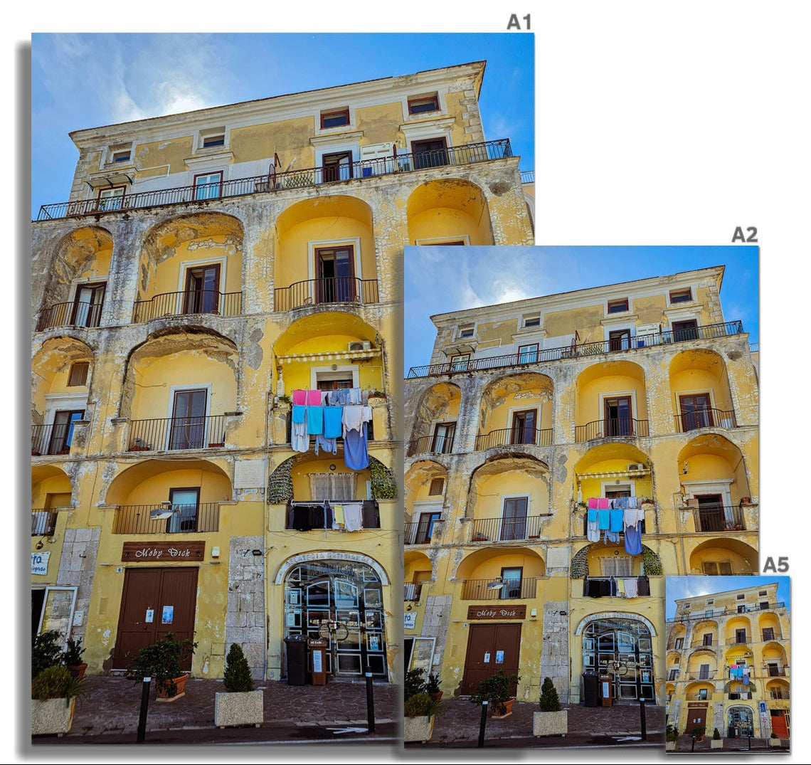 Panni al Sole fine art photograph of a weathered yellow Italian building with balconies and colourful washing in the sunshine